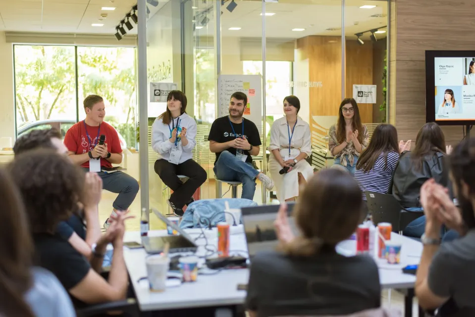 A panel of founders on stools talking to participants at their tables